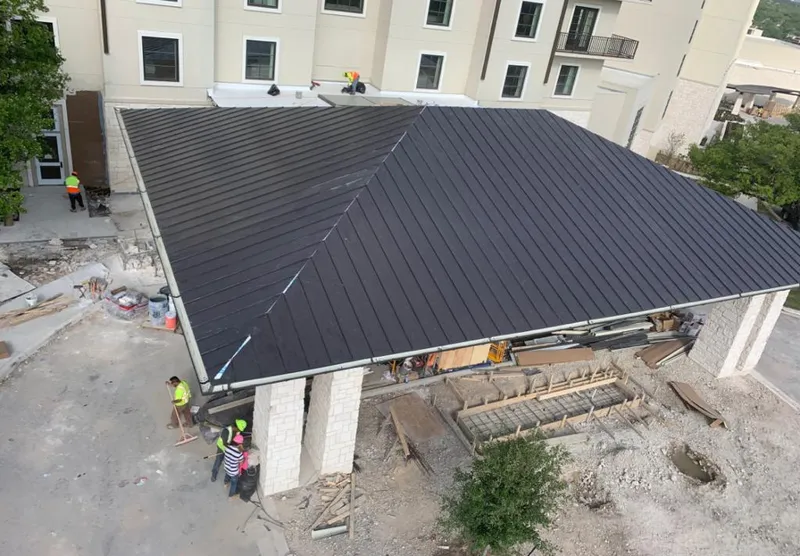Metal roofing installation team working on a commercial building in Leitchfield